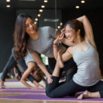 ヨガスタジオでマンツーマンでヨガを教わる女性